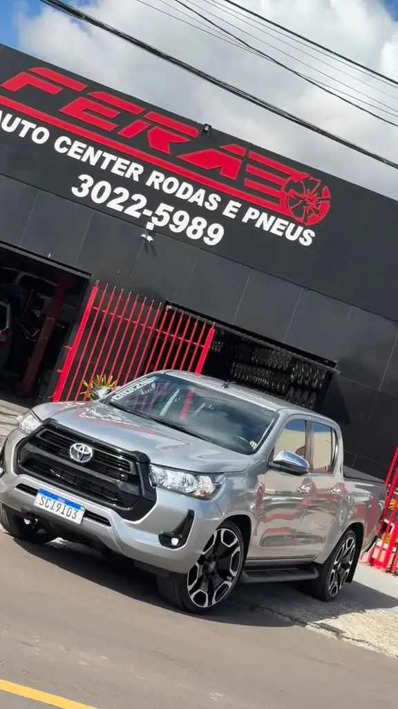 Toyota Hilux prata estacionada em frente à fachada da Fera Auto Center.