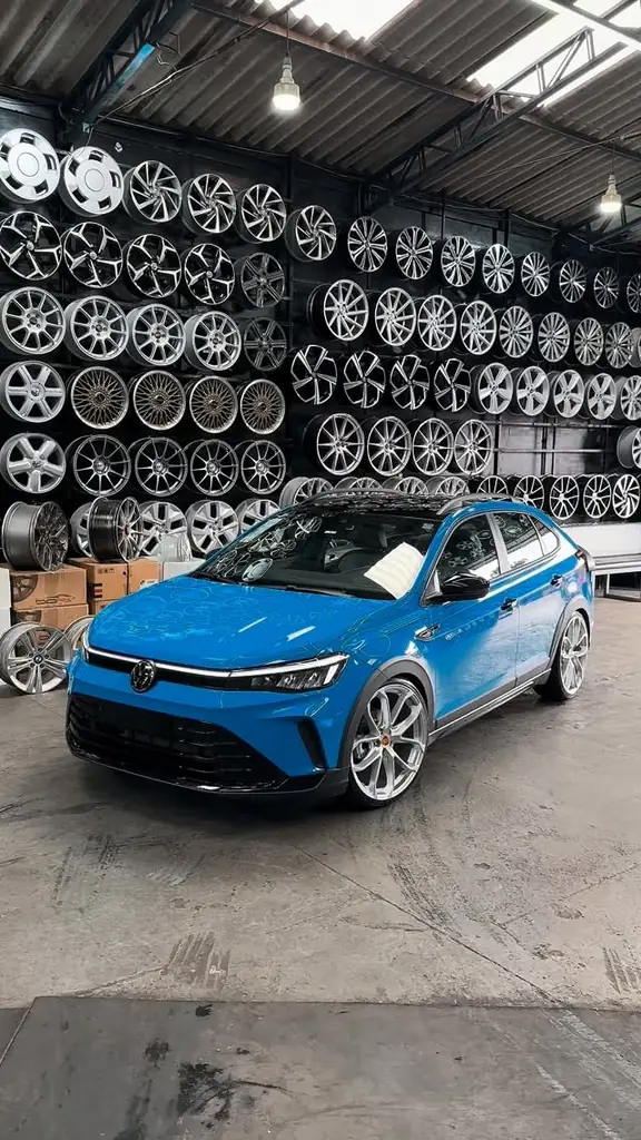 VW Nivus azul na loja da Fera, diante da parede de rodas.